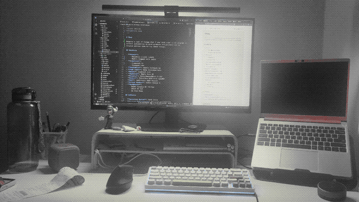 A desk with a monitor which shows a text editor and a browser.